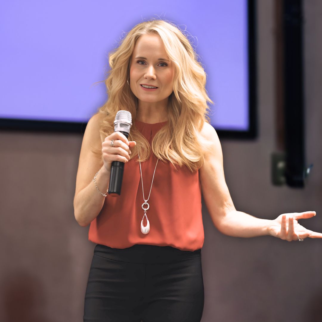 Alison Verge speaking on stage with a microphone